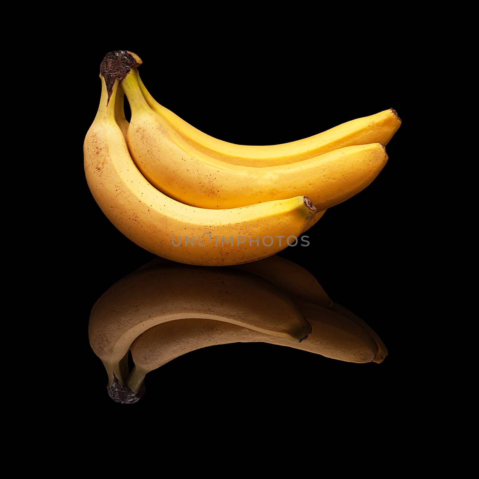 Bunch of ripe bananas with real reflection on a black background isolated