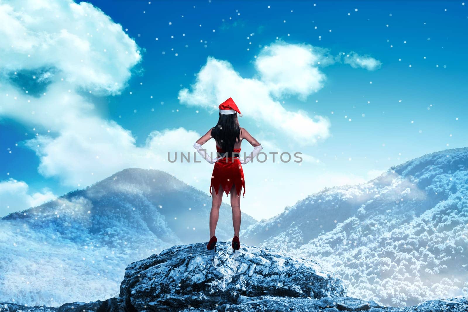 Asian woman wearing santa claus costume standing on the top of mountain looking the sky