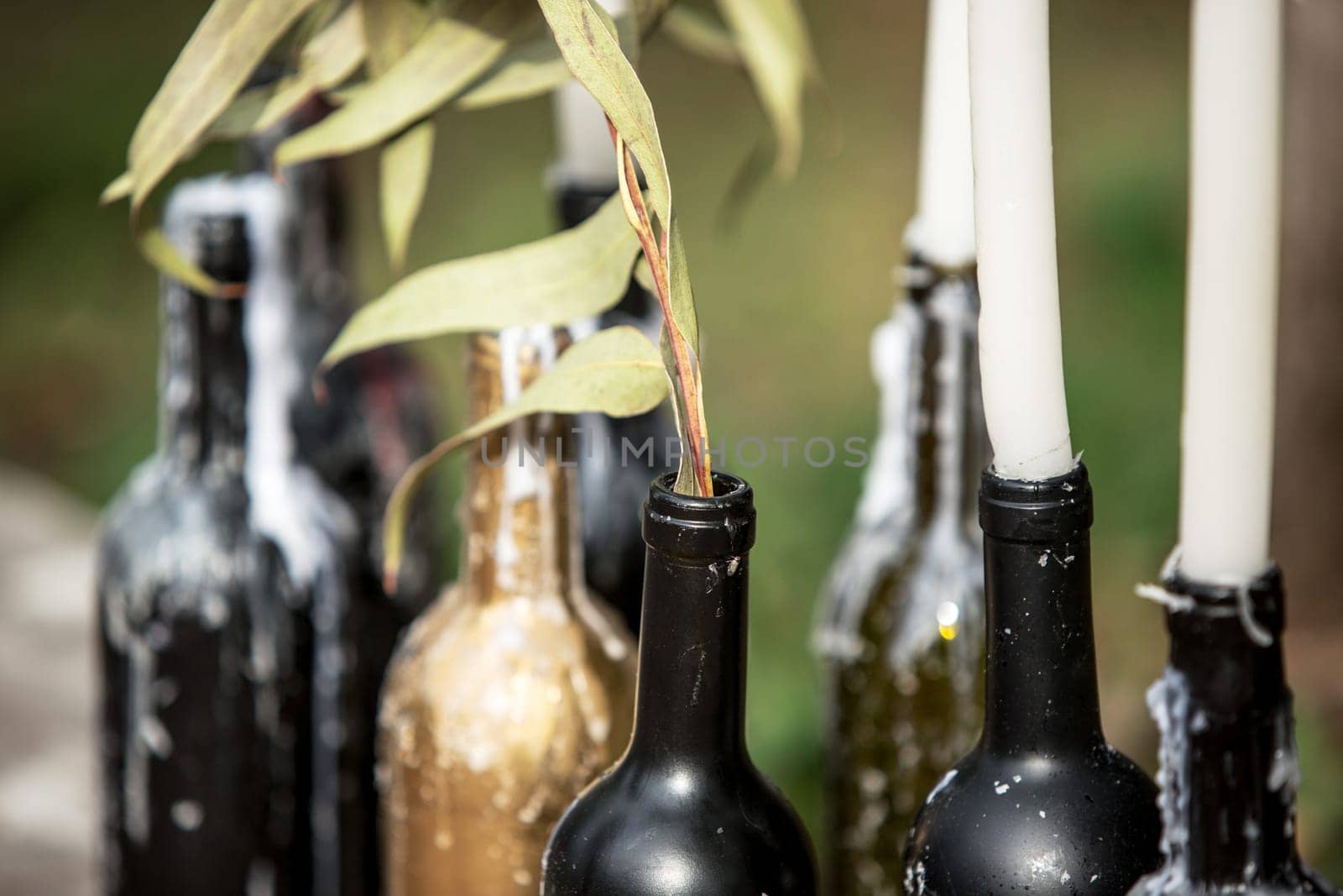 Burning candle in the vintage black bottle. Wedding decor