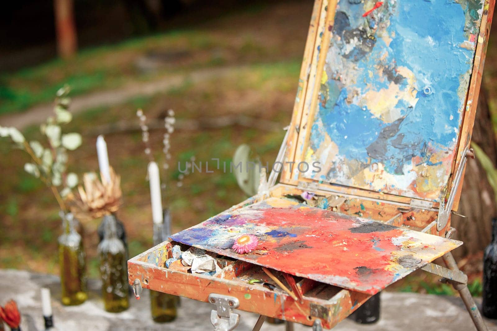 The tools of the artist - paints and brushes on forest background