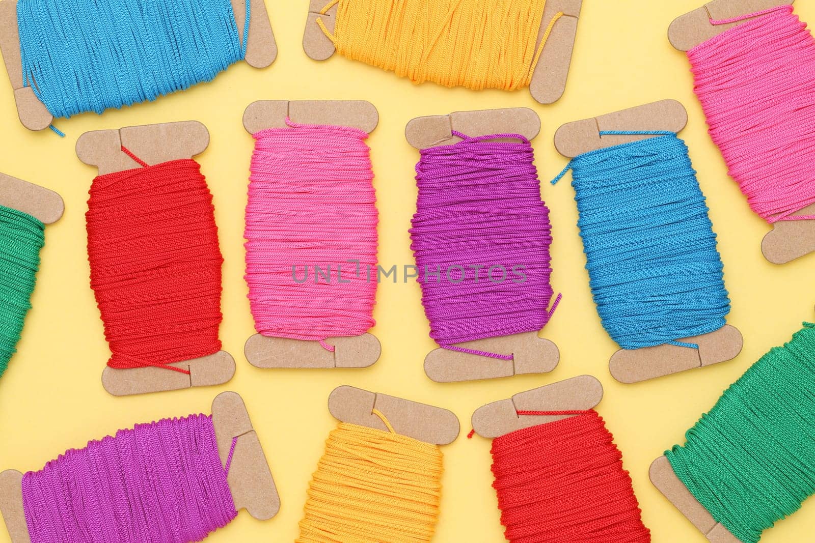 Spool of threads on yellow background