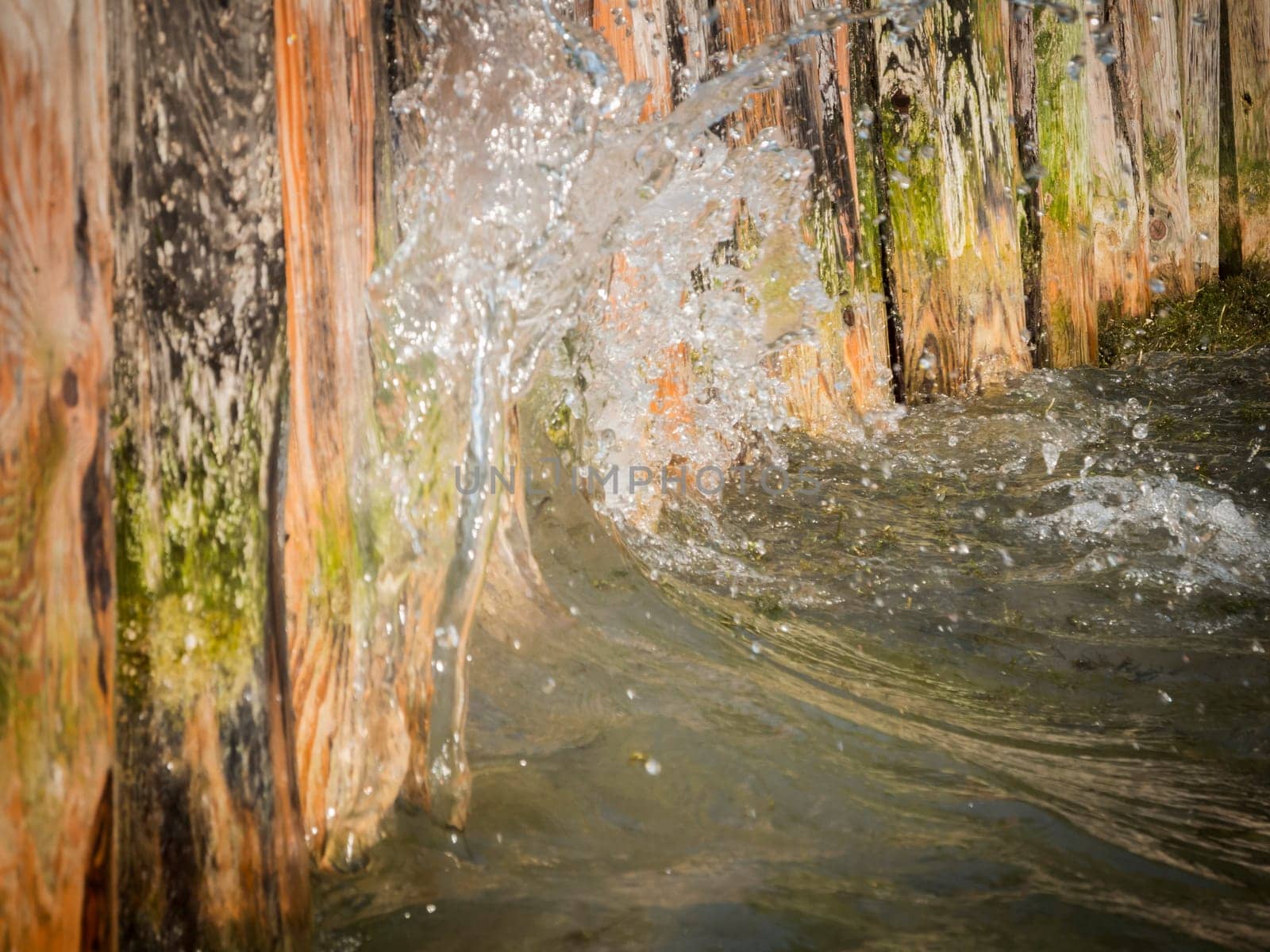 Close-up of water hitting a wooden shore fortification on Lake Caldaro.