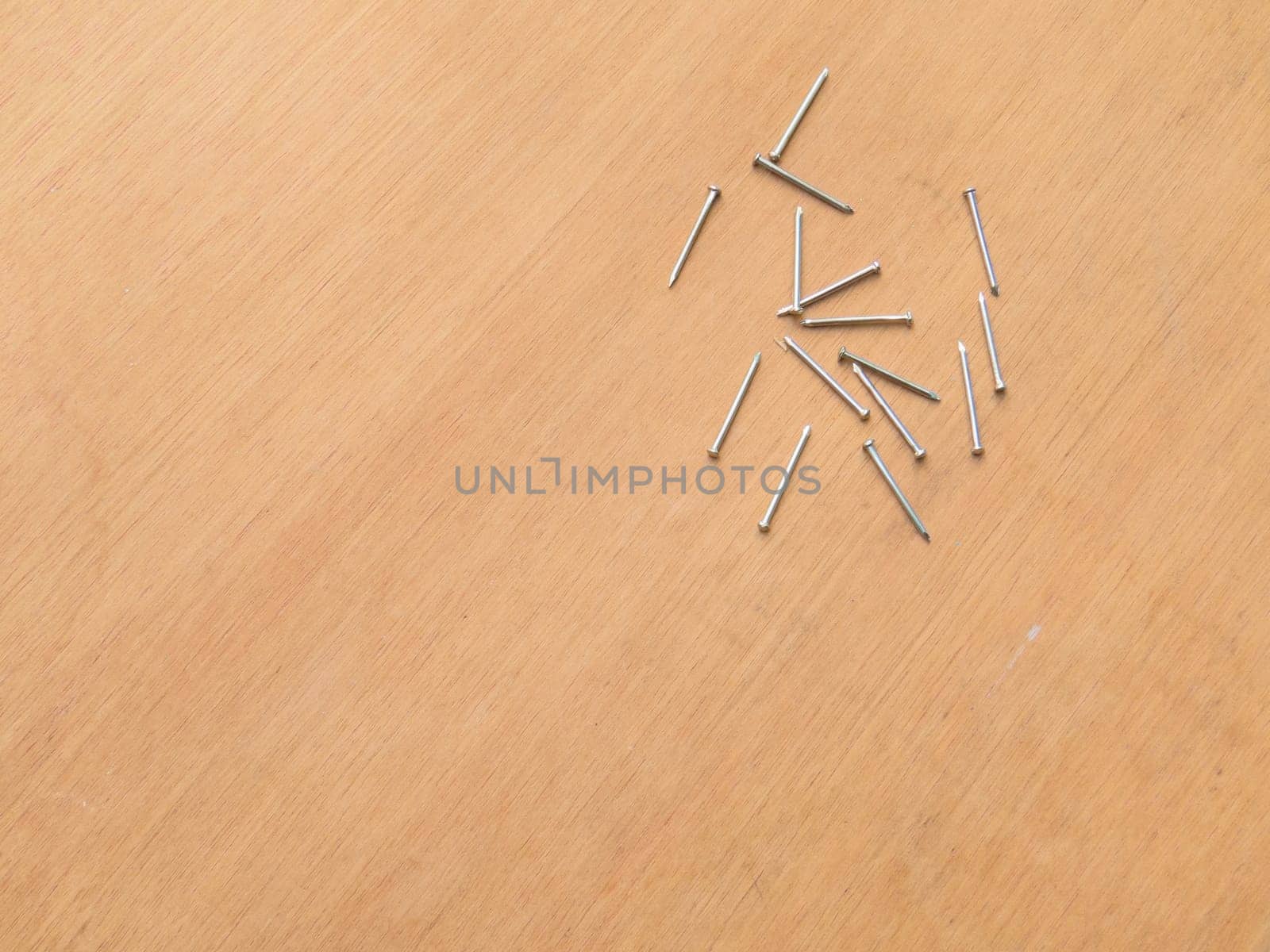 Carpentry material, several new nails on wooden background board