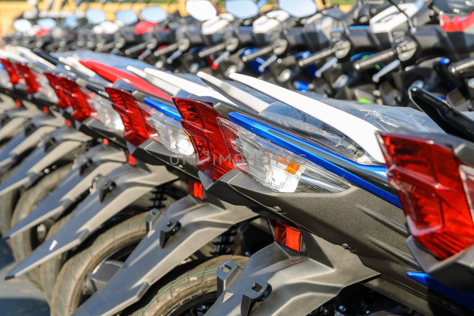 New motorcycles lined up at a store with close up on taillight, transportation background