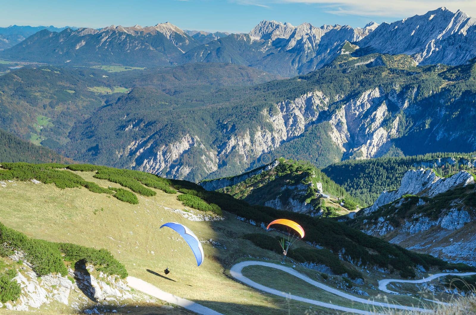 Pair paraplanes launching and soaring in Bavarian Alps mountains. Stock photo with aerial view on Alpine landscape.