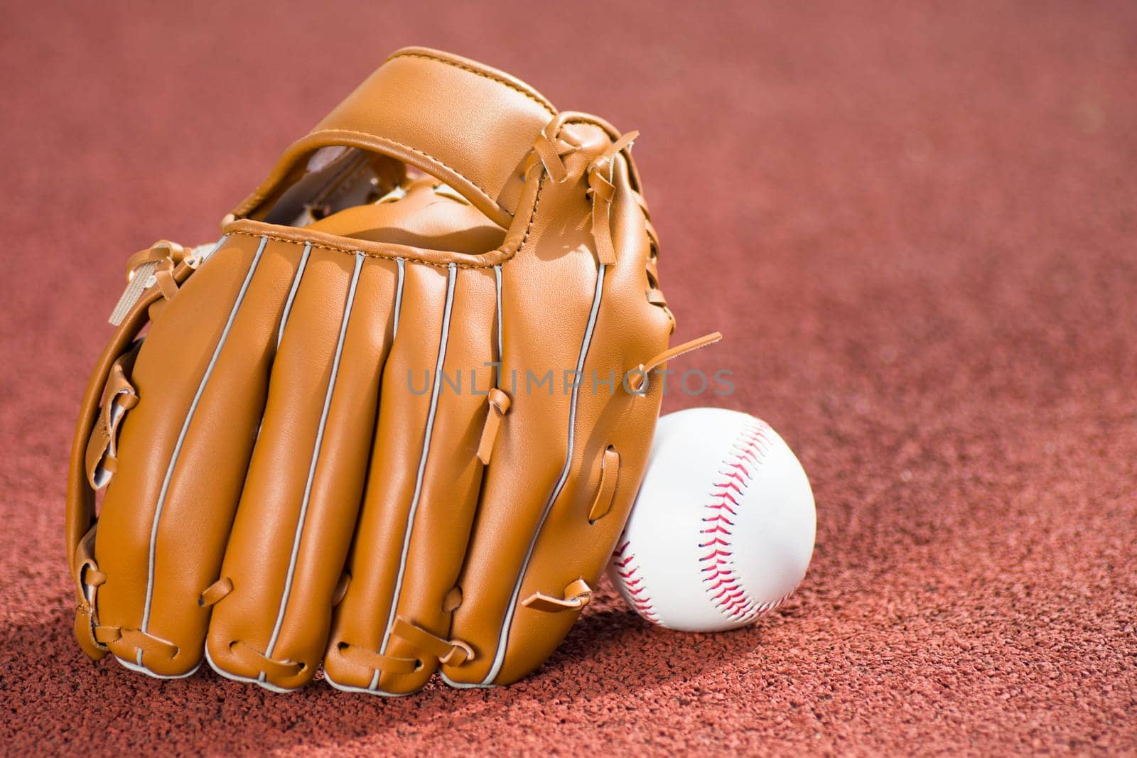 Baseball glove and ball on baseball field.
