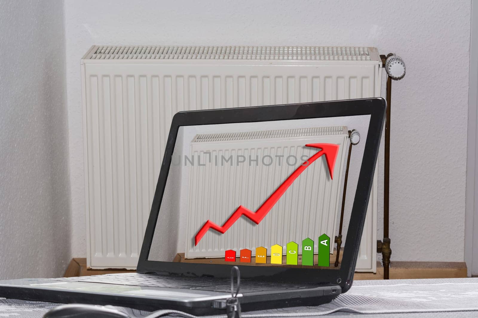 Laptop with picture of a radiator and diagram on the monitor. Concept saving heating costs,construction planning and architecture.