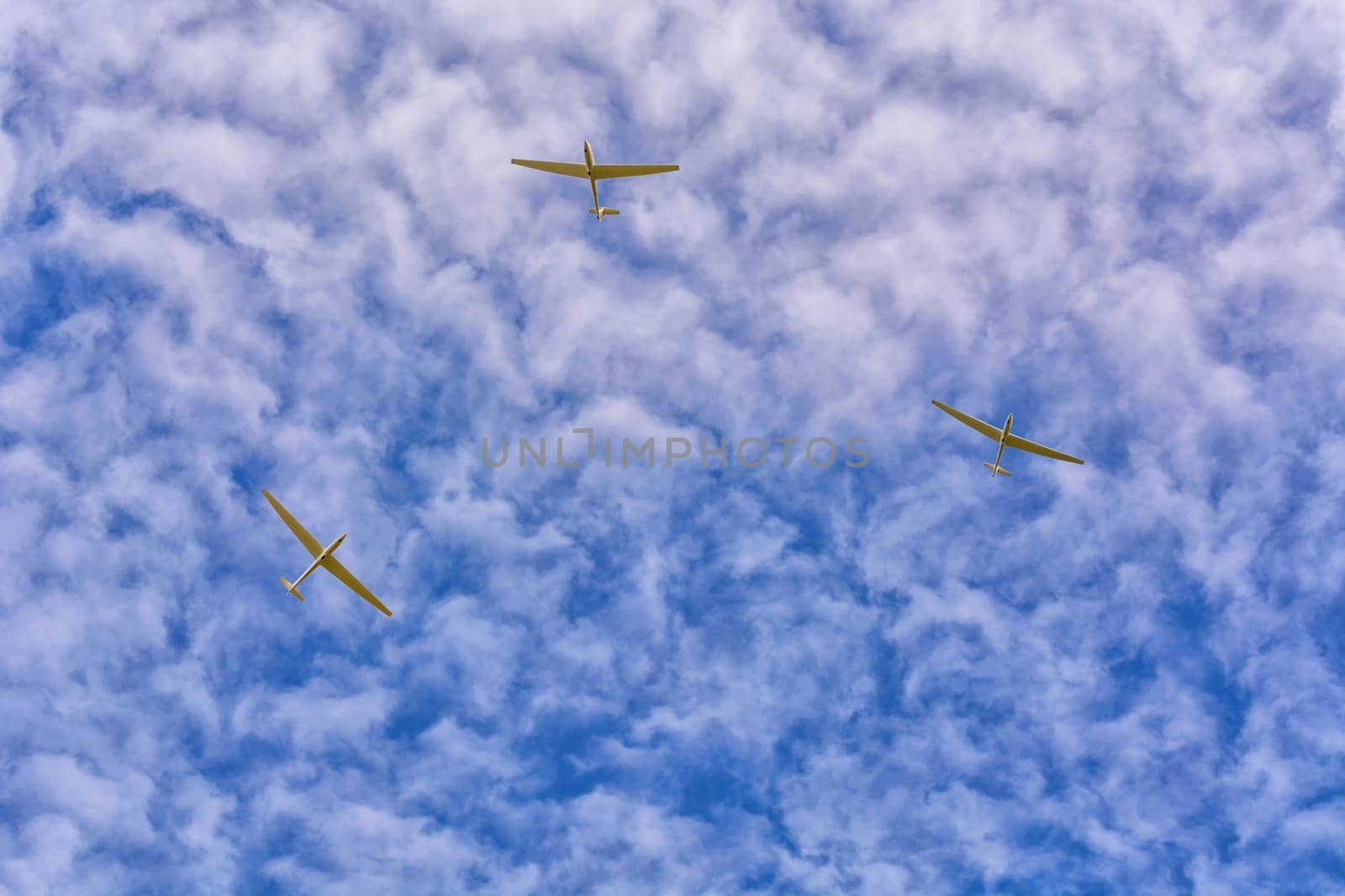 3 gliders in the blue sky. Motorless flying with a glider by using the thermals.