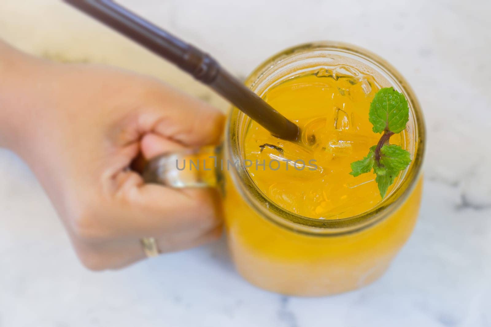 Orange juice with ice cube on marble table, stock photo