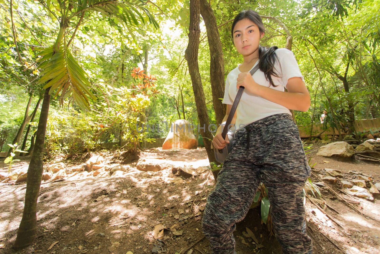 Young asian woman near public board with map, routes and locations