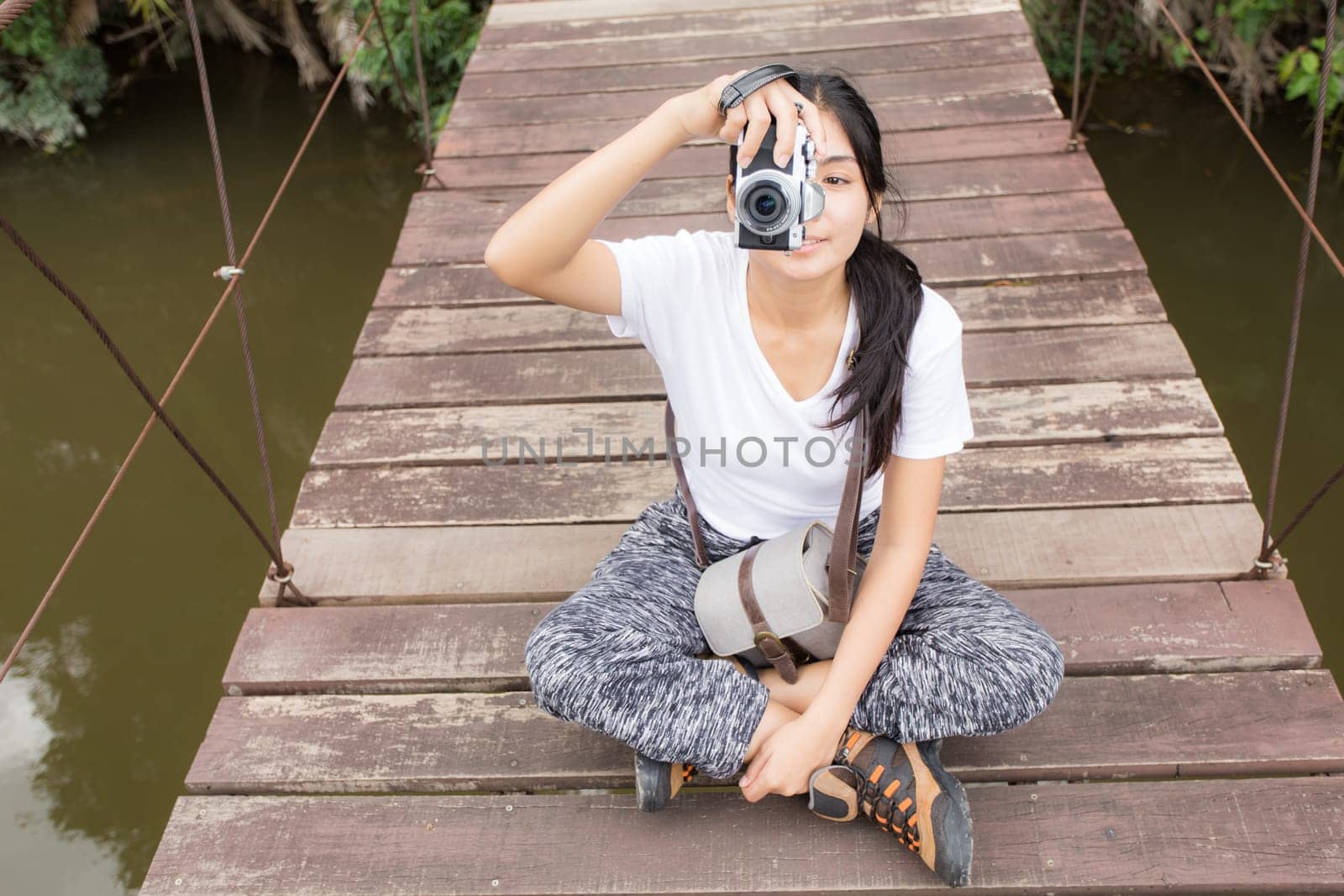 Young asian woman near public board with map, routes and locations