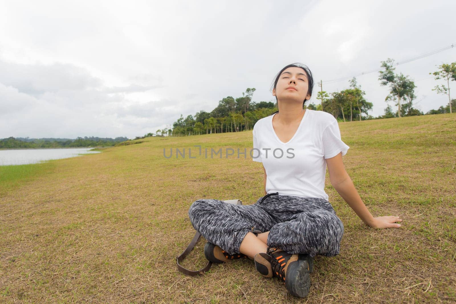 Beautiful smiling young asian woman enjoying yoga, relaxing, feeling alive, breathing fresh air, got freedom from work