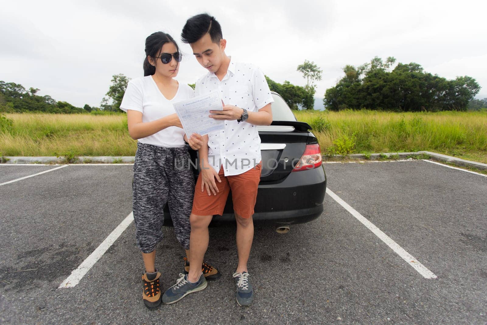 Couple after a car breakdown at the side of the road, woman take a phoen for emergency team