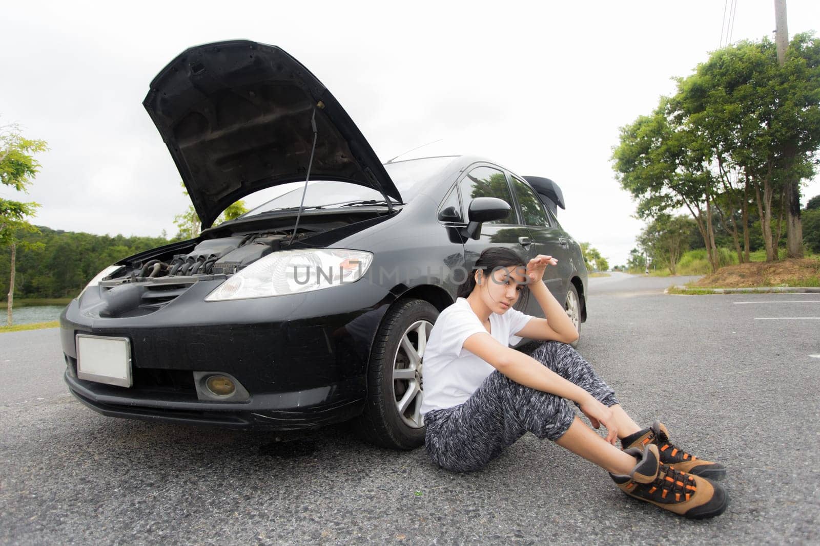 Woman opened the hood Broken car on the side See engines that are damaged or not