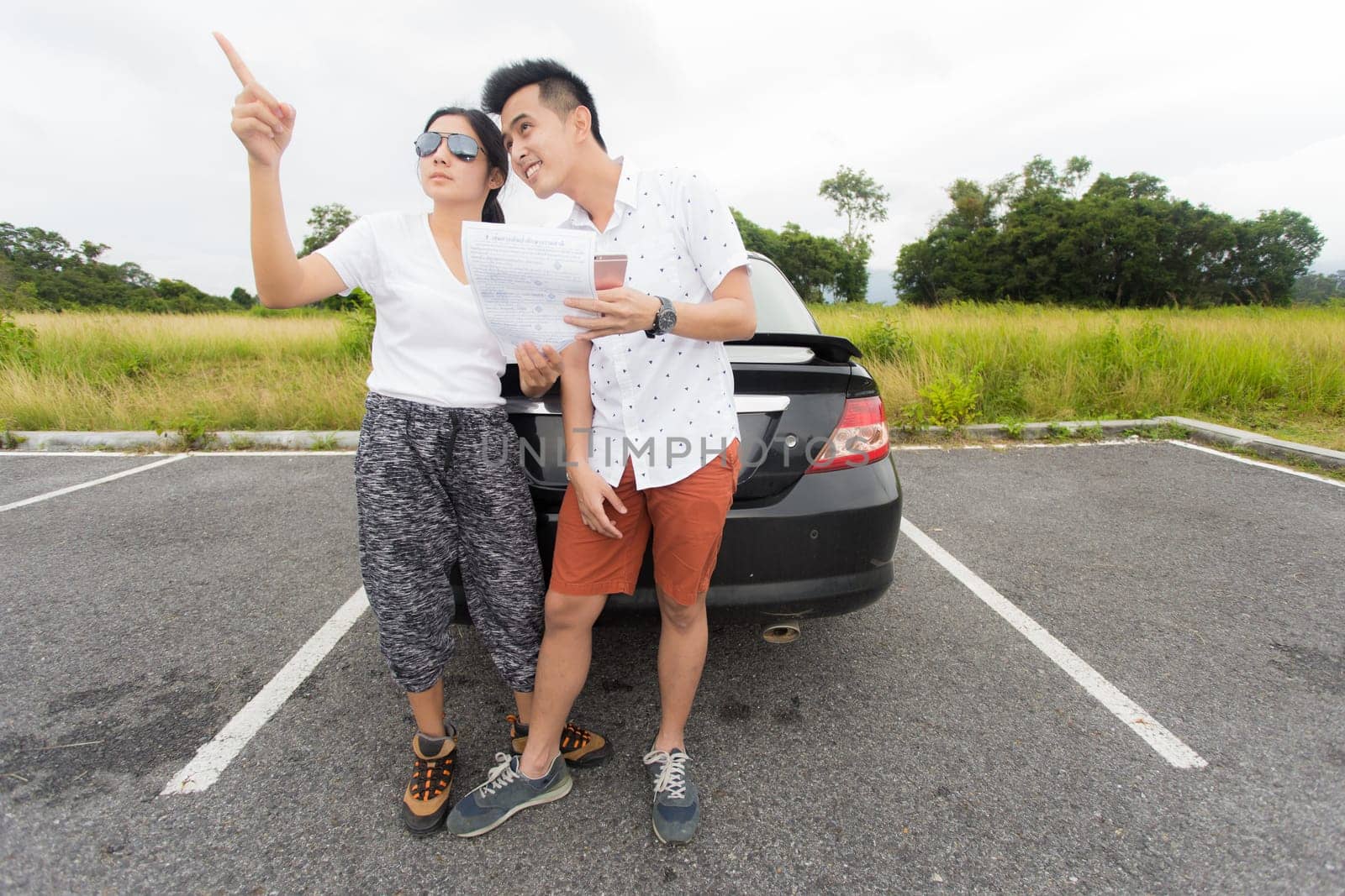 Couple after a car breakdown at the side of the road, woman take a phoen for emergency team