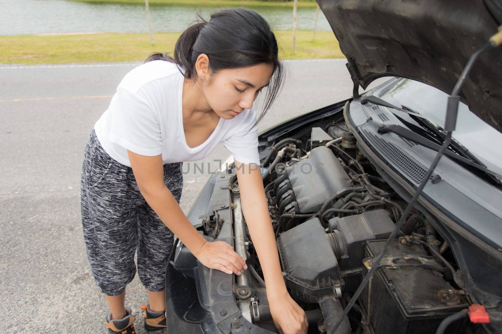 Woman opened the hood Broken car on the side See engines that are damaged or not