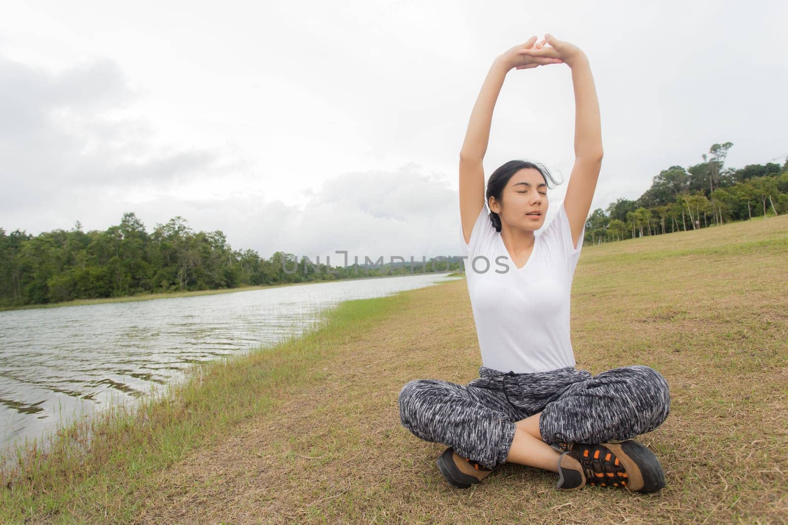 Beautiful smiling young asian woman enjoying yoga, relaxing, feeling alive, breathing fresh air, got freedom from work