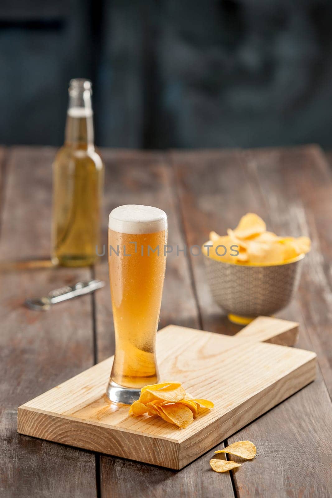 The glass of Beer and potato chips, pistachios isolated on a white
