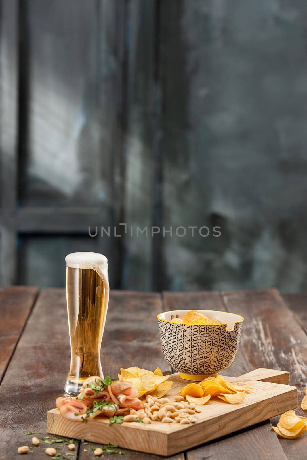 The glass of Beer and potato chips, pistachios isolated on a white