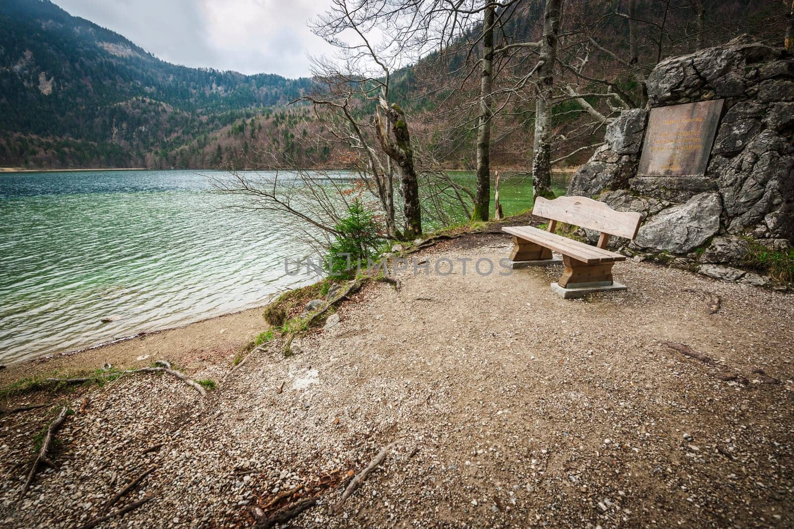 Wide-angle view of a rest area on the Alpsee with bench and memorial plaque to Queen Mother Marie of Bavaria.