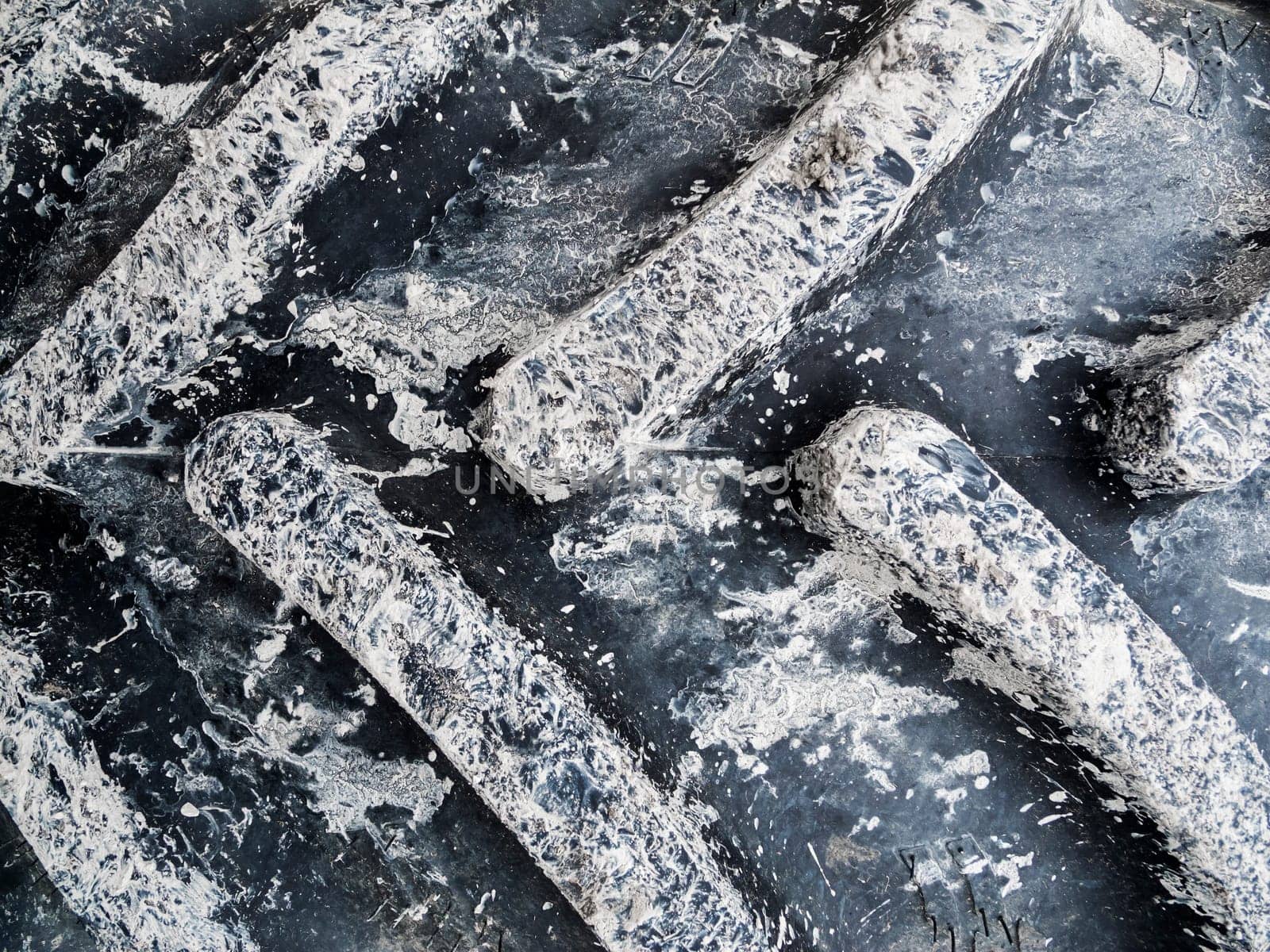 Format-filling view of a tractor tire with mud tracks.