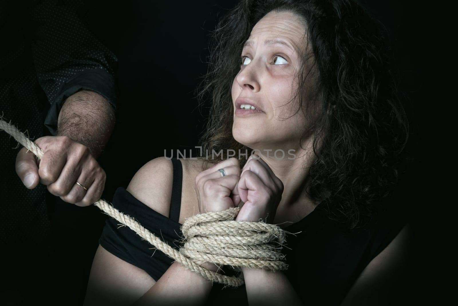Abused woman, tied with rope victim of domestic violence