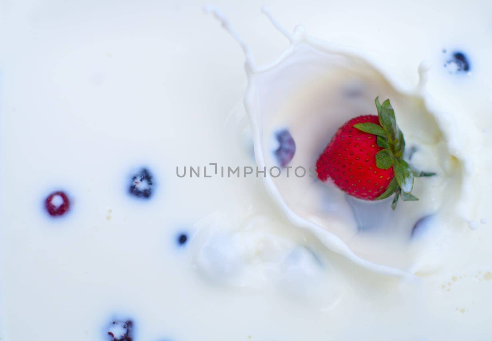 red strawberries and blueberries in cream or milk dairy product and organic fruit