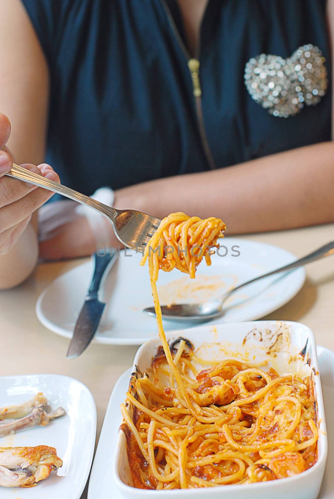 woman eat spaghetti with the great flavors of fresh shrimp and blended in tomato sauce, baked & topped with mozzarella cheese.