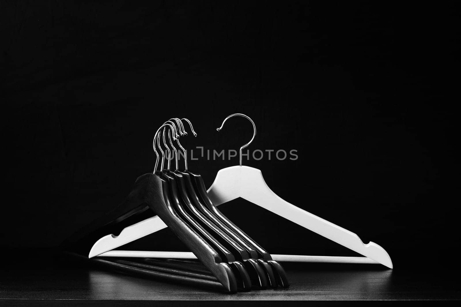 White hanger and a few black hangers, black background, abstract