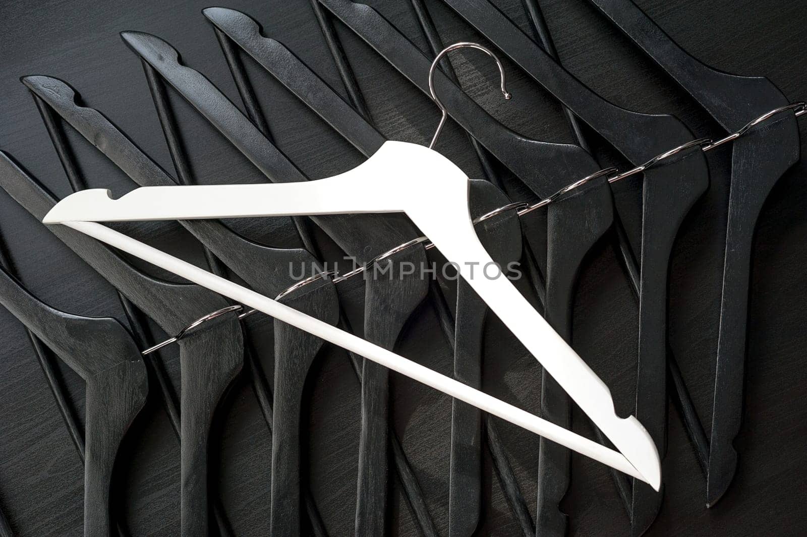 White hanger and a few black hangers, black background, abstract