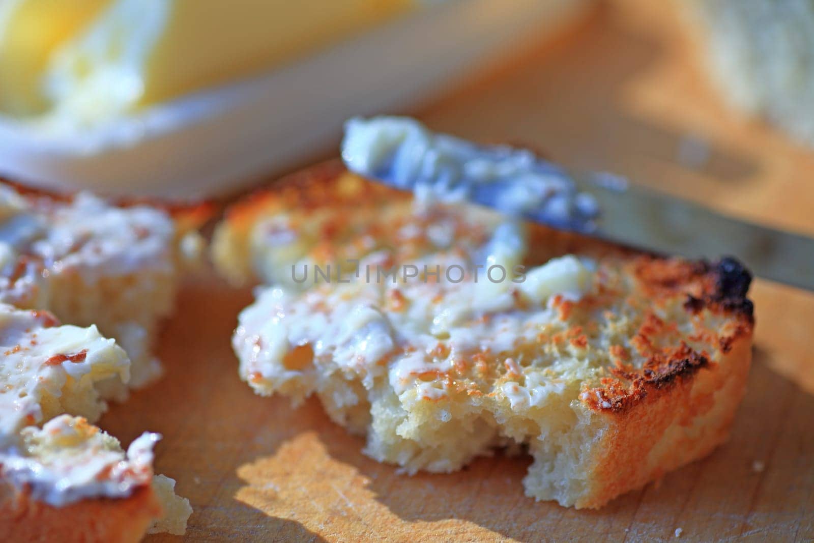 Buttering toast with bright morning light