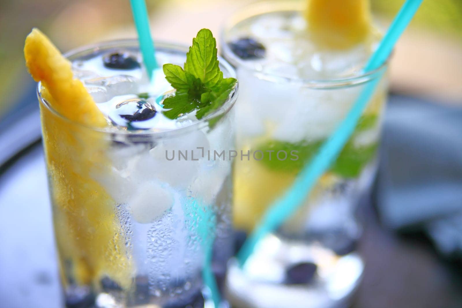 Glasses of white wine with fresh pineapple, blueberries and mint with crushed ice