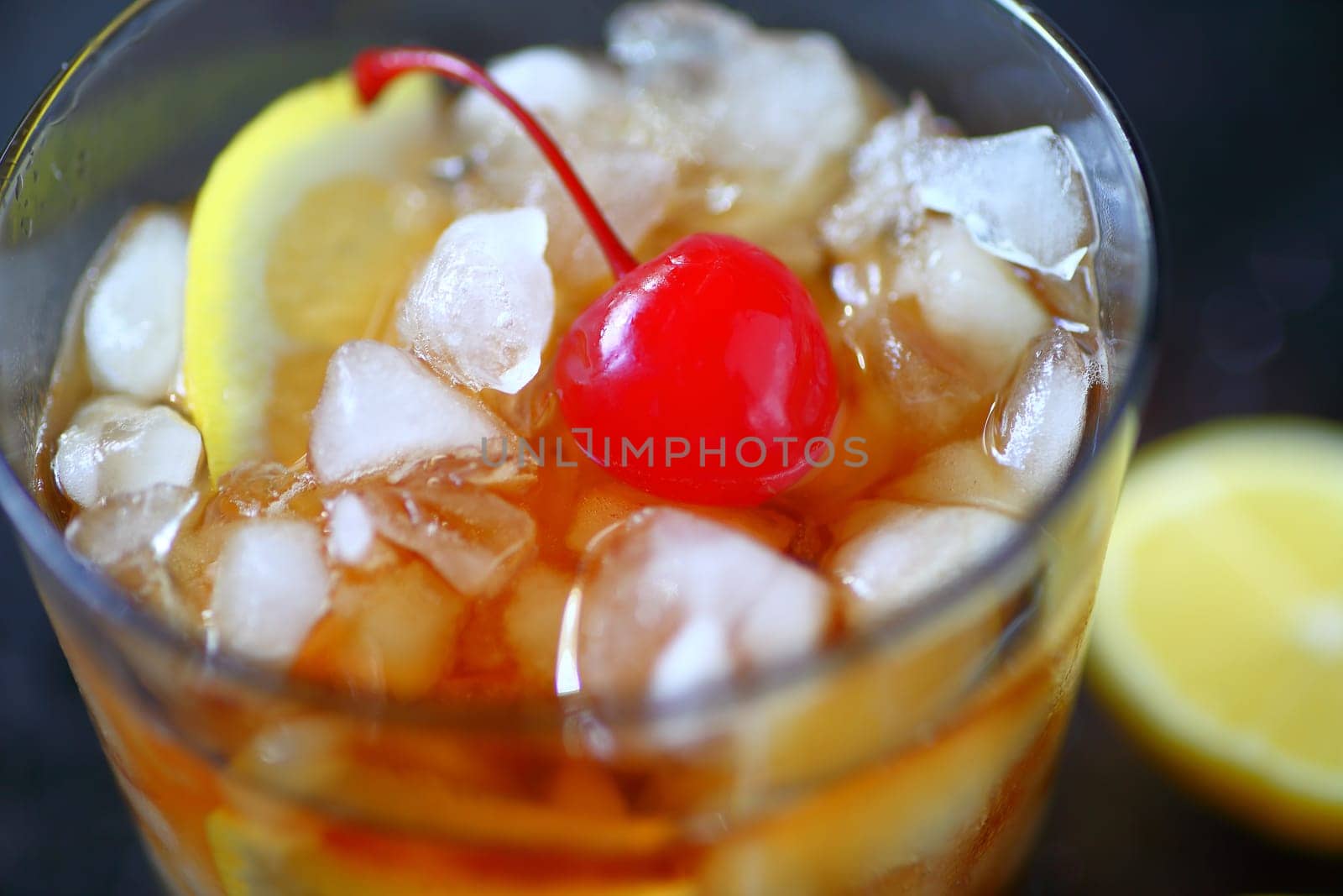 Whiskey sour cocktail with lemon, crushed ice and a cherry