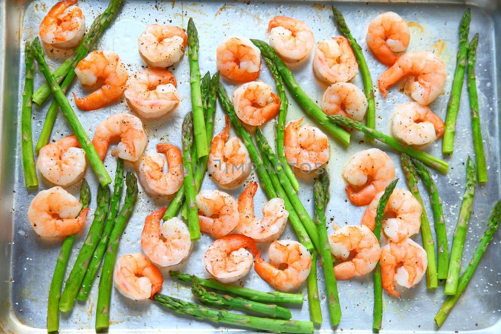 Sheet pan dinner of shrimp and asparagus with olive oil and black pepper