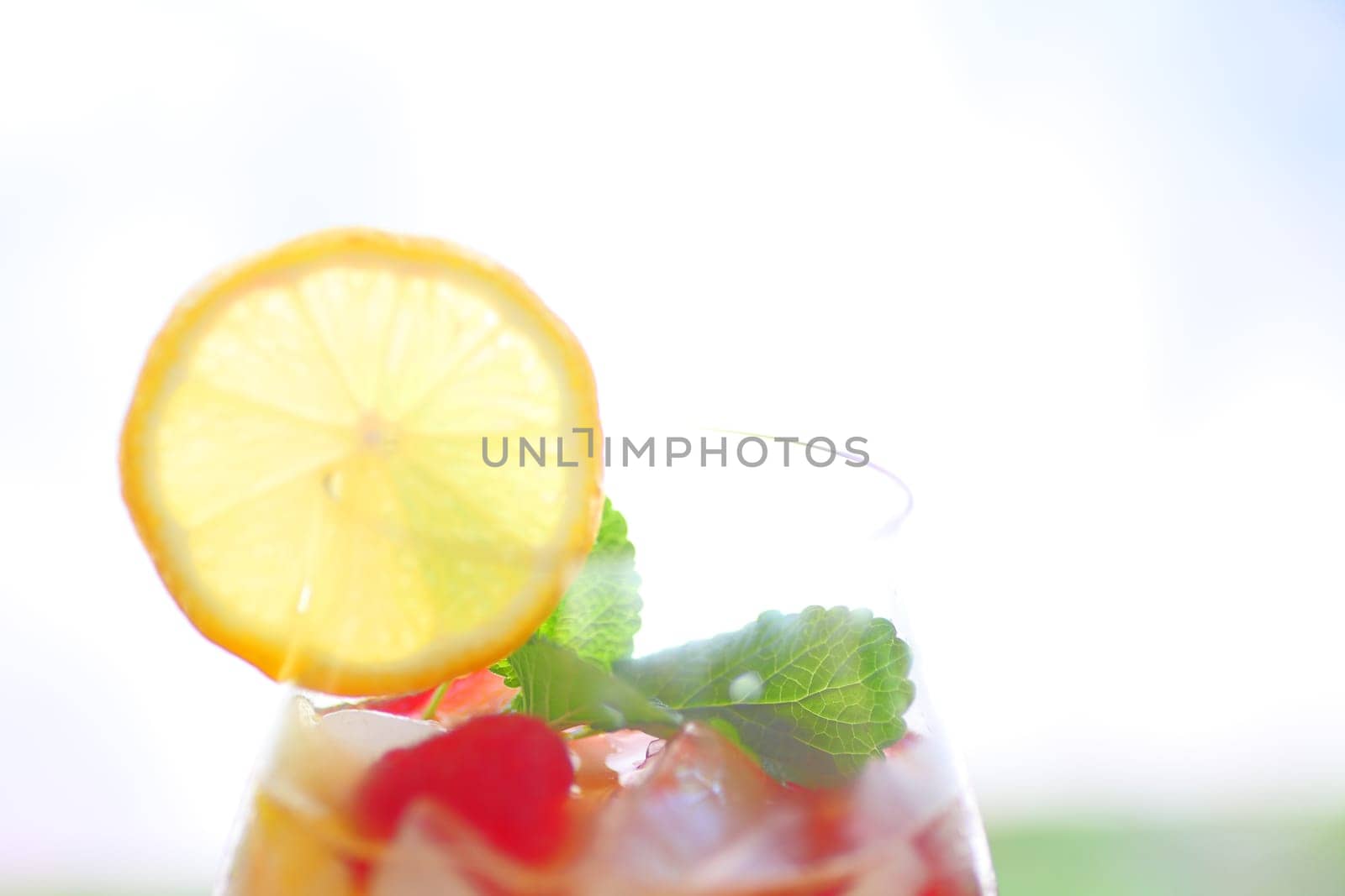 Icy drink of white wine with fresh berries, mint and lemon with copy space