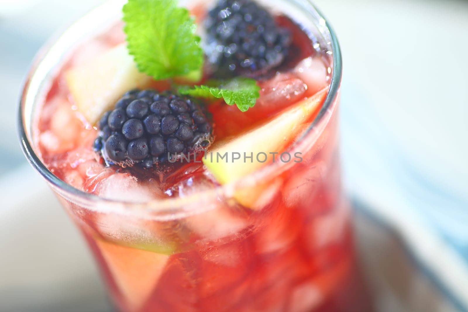 Closeup of icy wine cocktail with fresh apple and blackberries