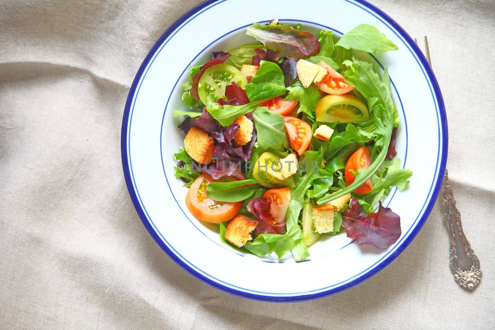 Salad with miniature heirloom tomatoes, mixed young lettuces and croutons with copy space
