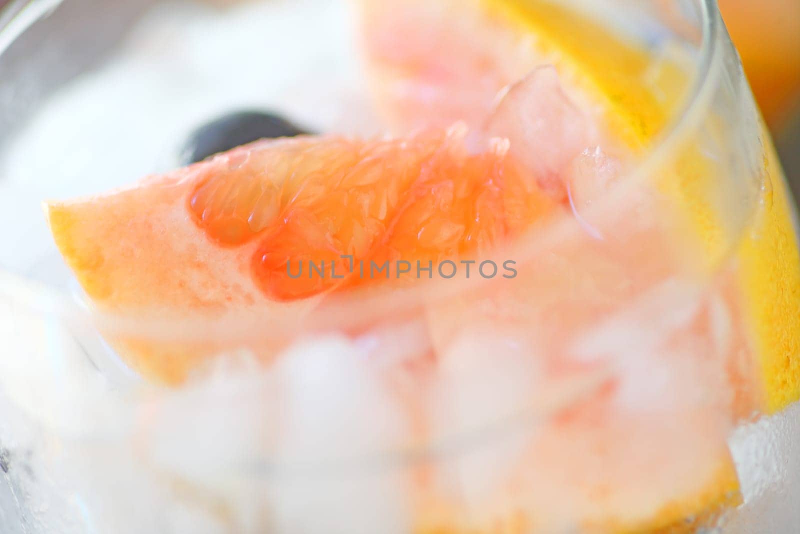 Closeup of nonalcoholic cold drink with grapefruit, blueberries and crushed ice