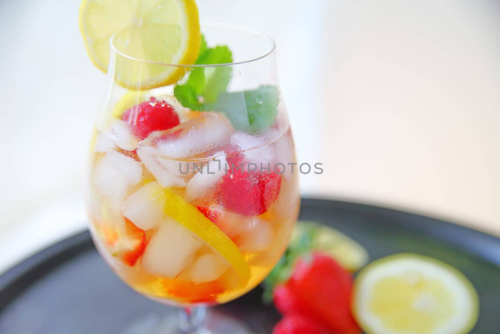 Wine cocktail with fresh berries, lemon and mint over ice