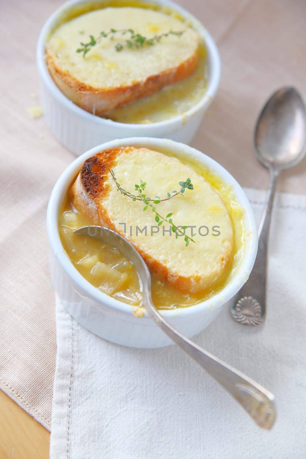 Overhead view of small bowls of onion soup with toasted cheese and fresh thyme topping
