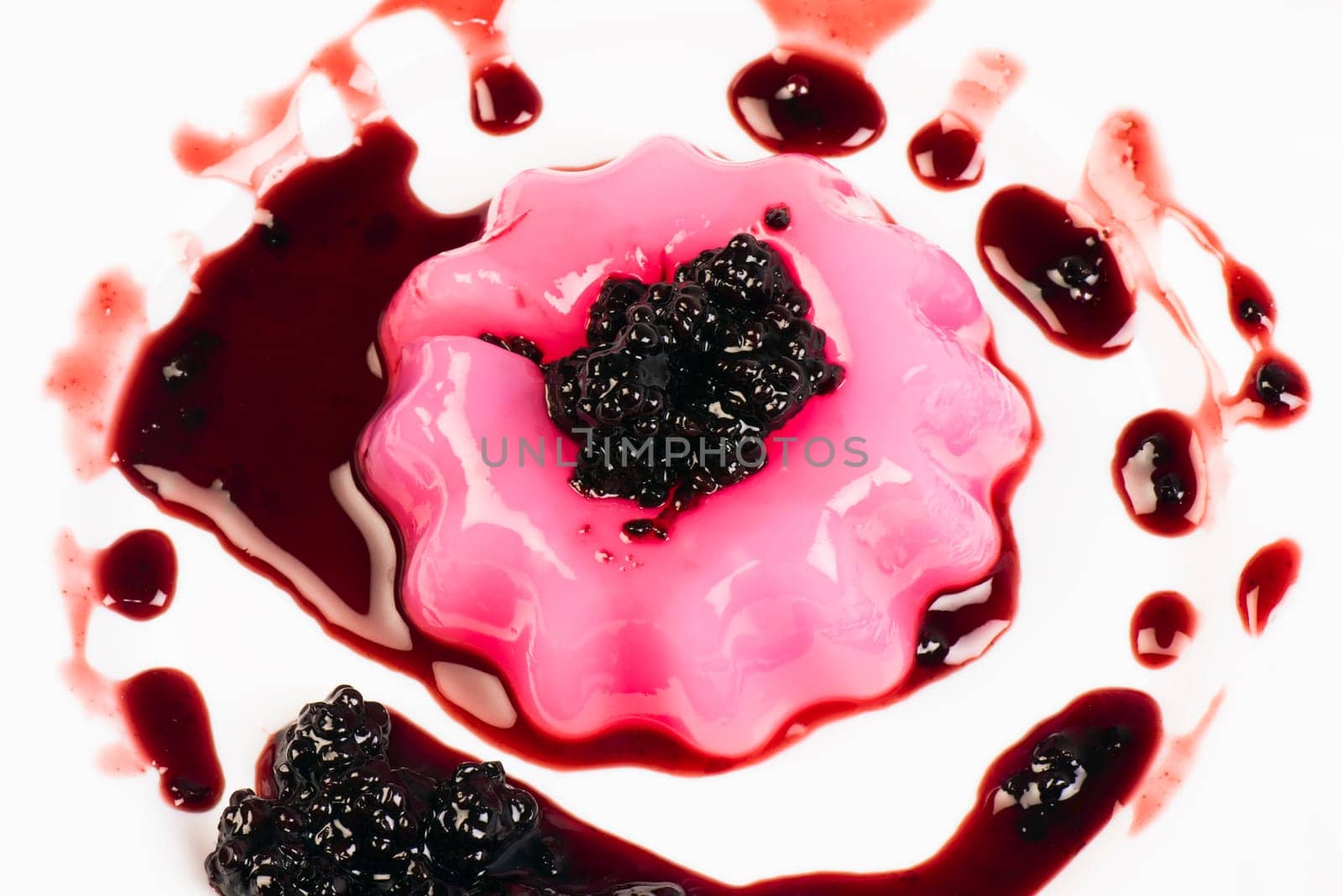 Pink pudding with sweet sauce of blackberry.