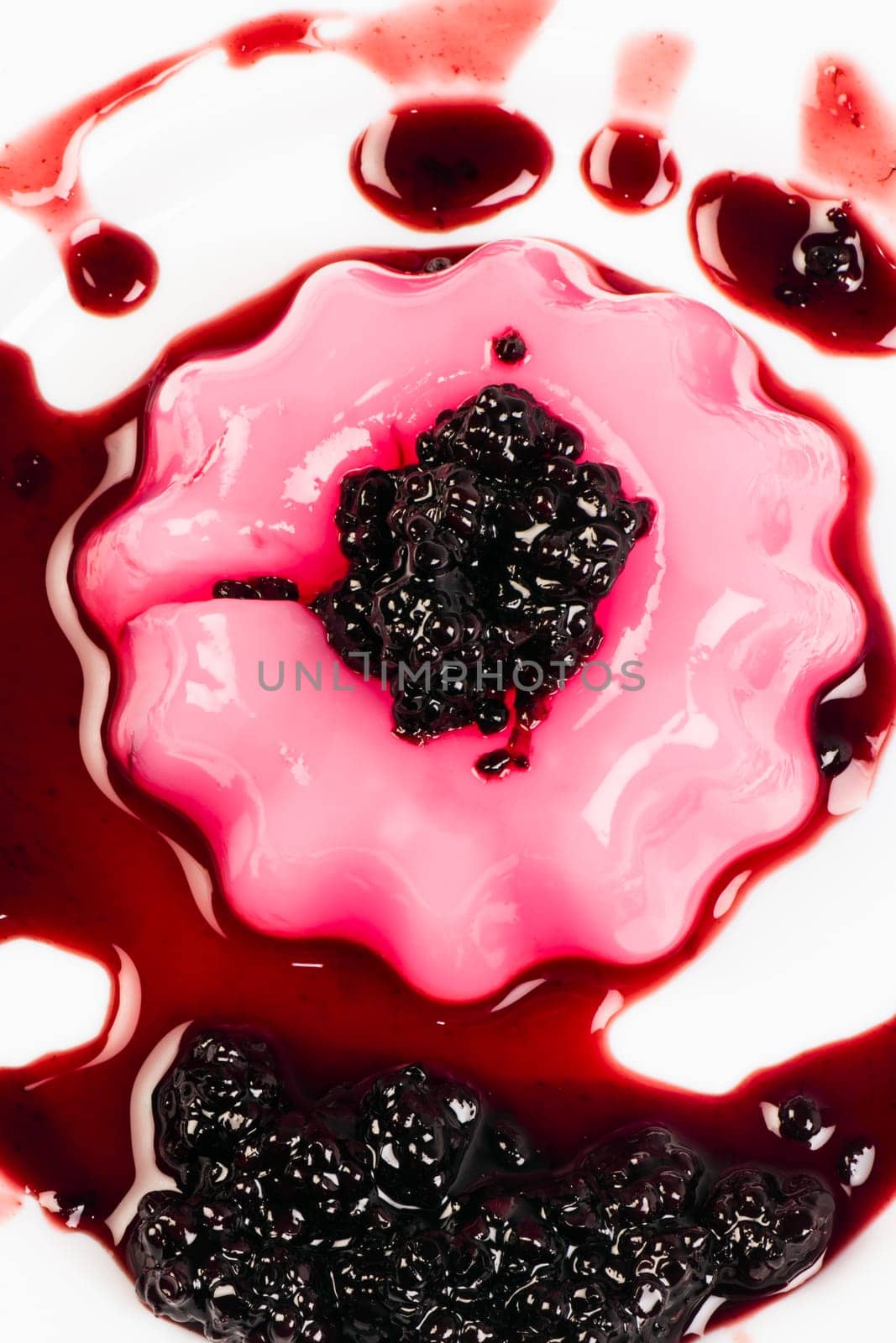 Pink pudding with sweet sauce of blackberry.
