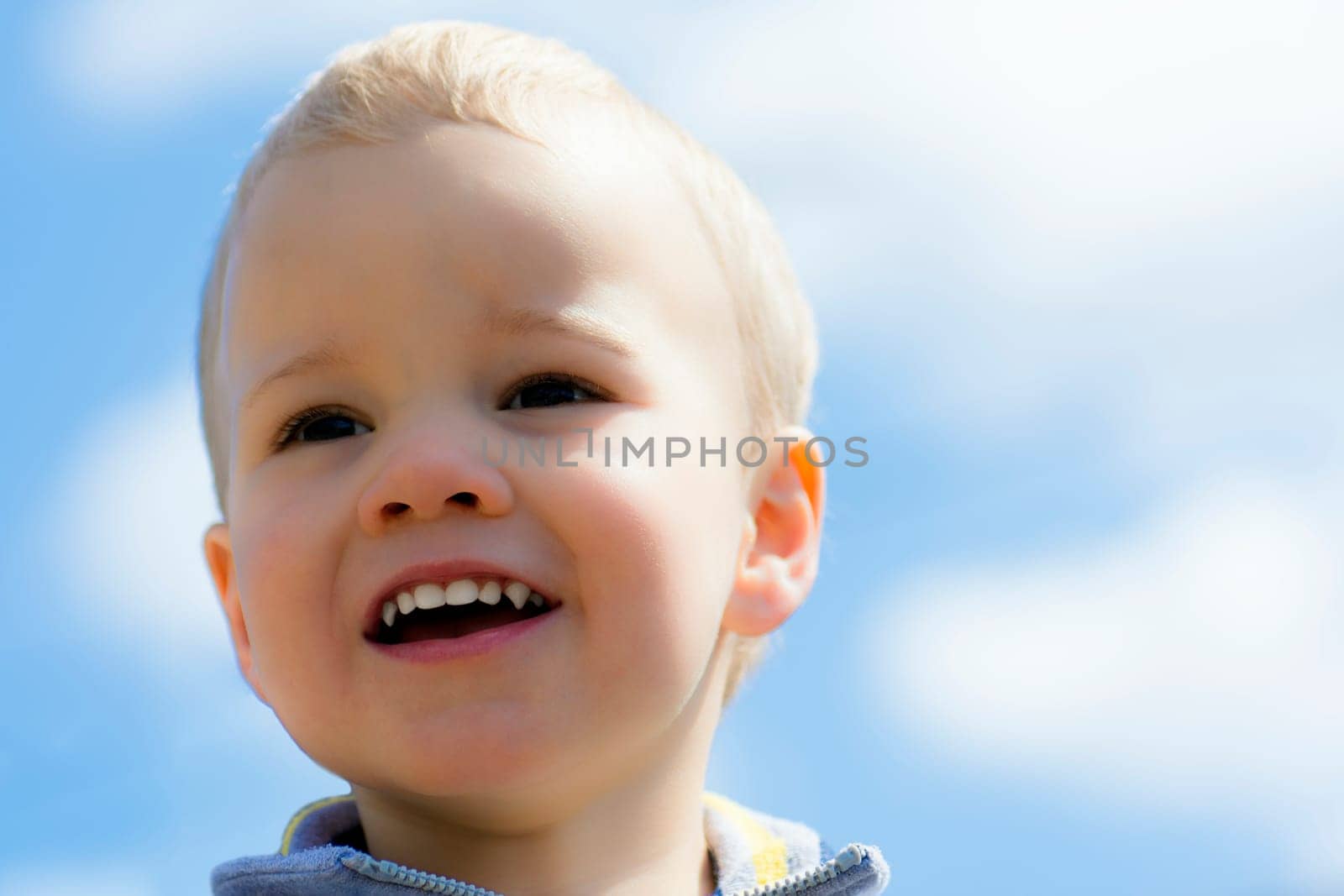 Portrait about a happy little boy with blonde hair.