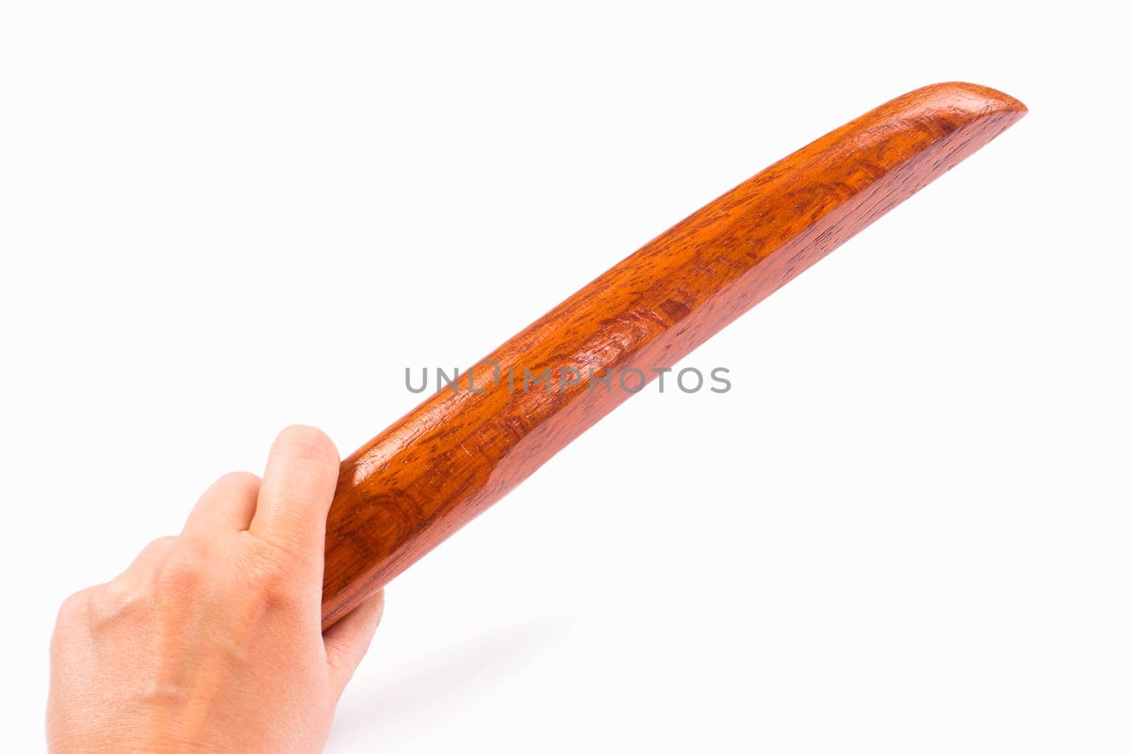 The hand holds a wooden tanto isolated on white background.