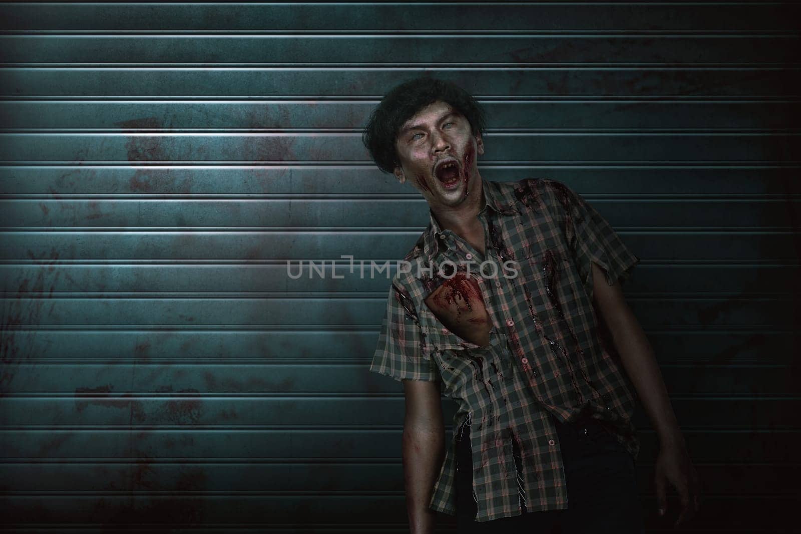 Scary asian zombie man with claw hand standing on the dirty background