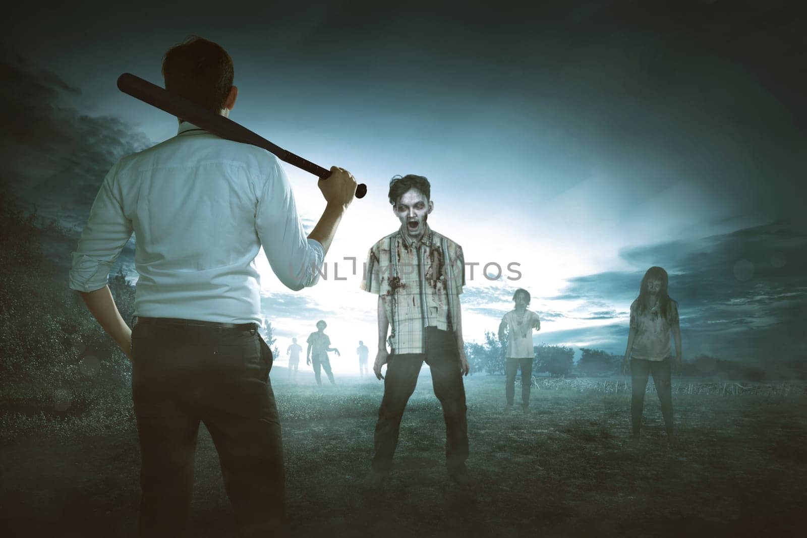 Back view of asian man holding baseball bat against zombies on the scary countryside