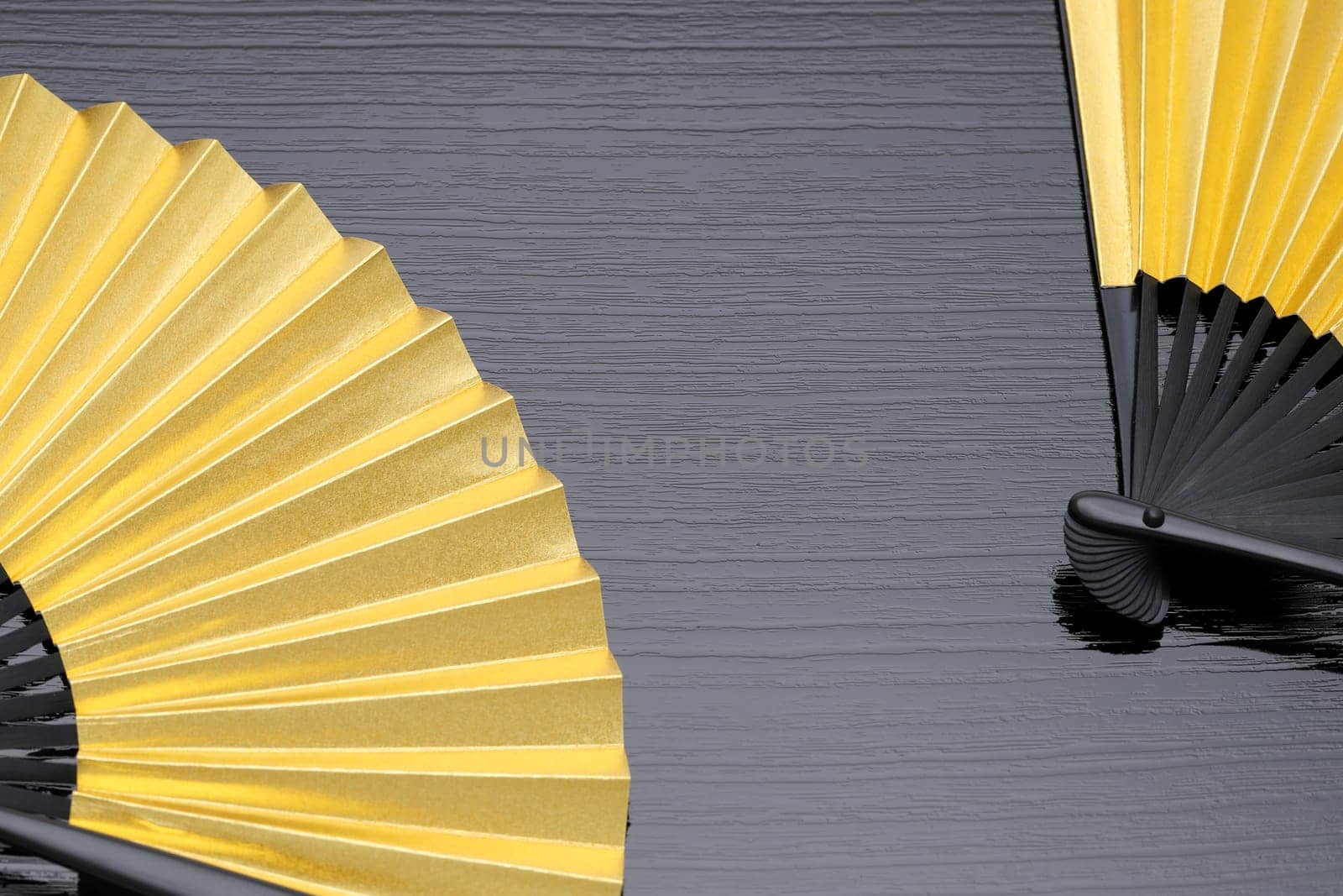 traditional japanese style golden hand fan on gray background