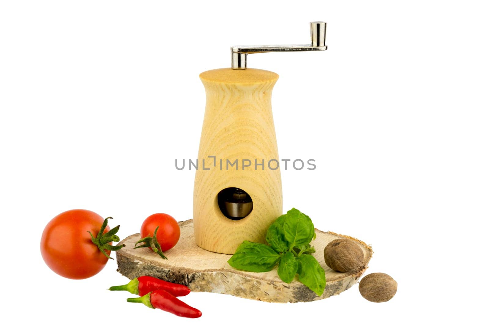 Nutmeg mill on wooden board with basil leaves,tomatoes,peppers and nutmeg