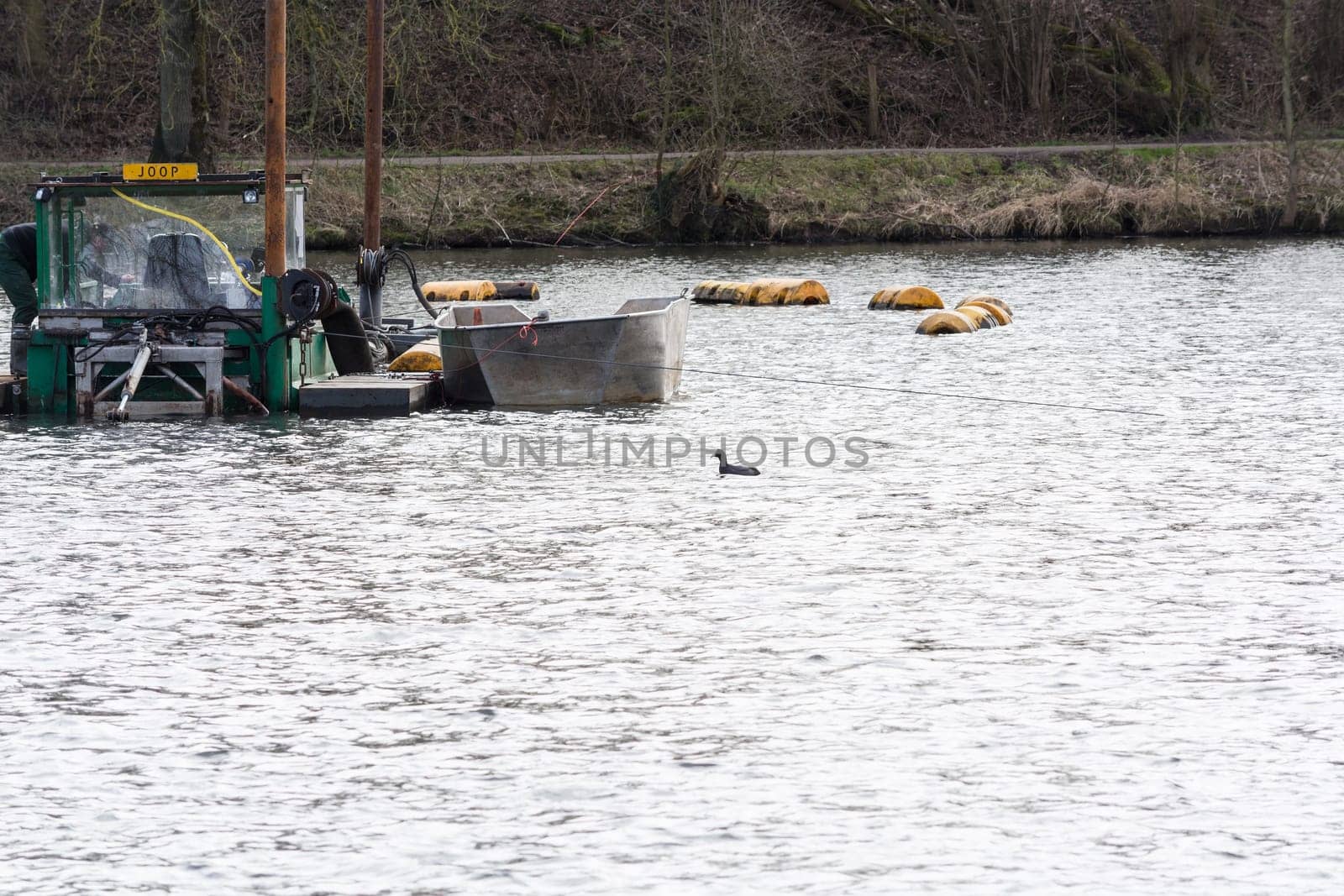 HEILIGENHAUS, NRW, GERMANY - MARCH 03, 2017:.Special ship, working platform in use on a small pond. Wet dredging at the Abtskuecher Teich in Heiligenhaus.