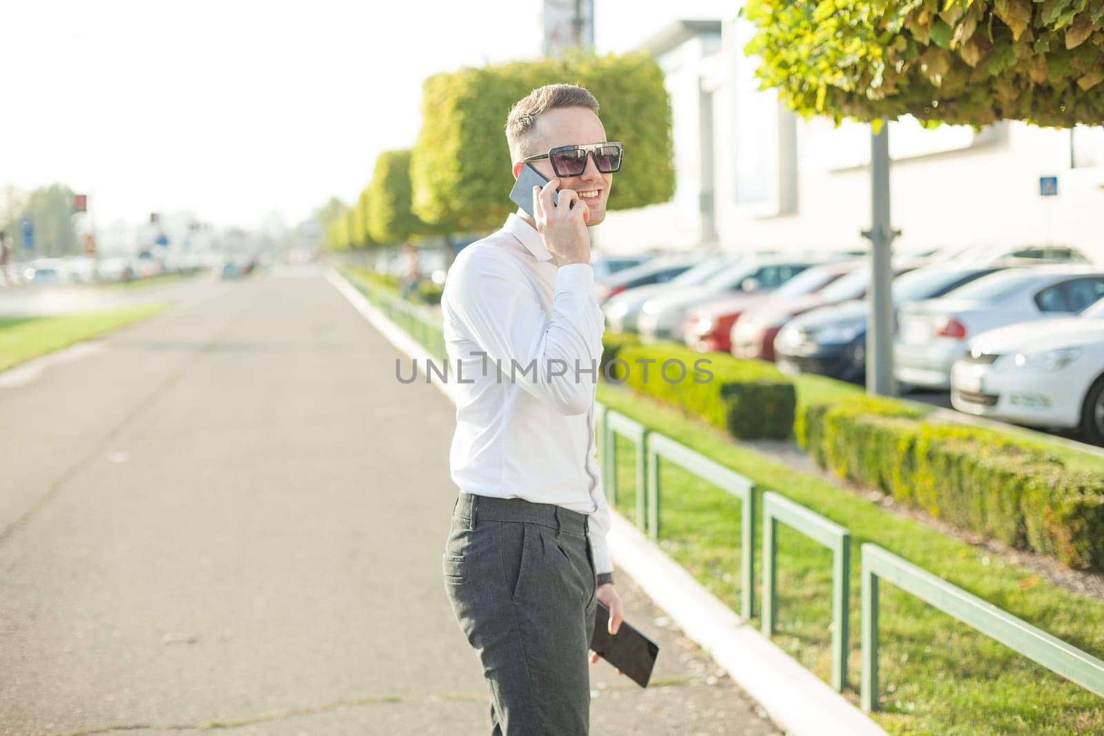 Businessman Man With Mobile Phone and Tablet computer in hands, In City, Urban Space